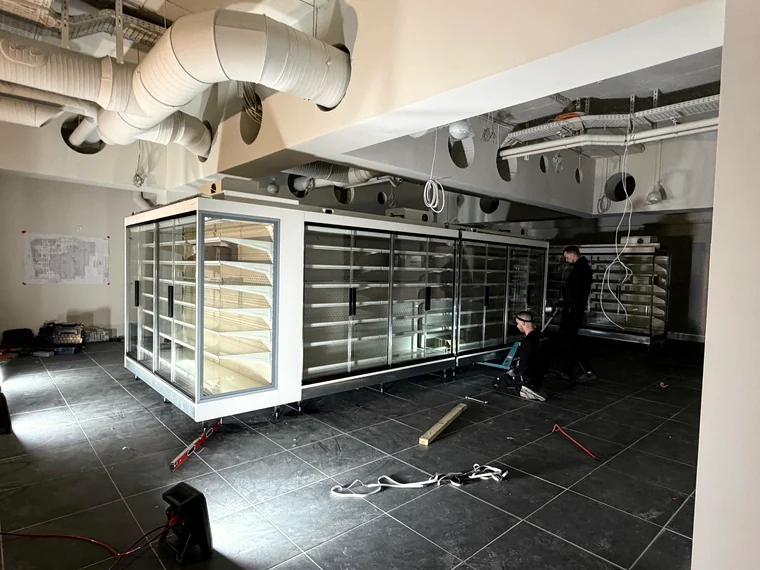 Zwei Monteure richten eine Kühlmöbelanlage aus