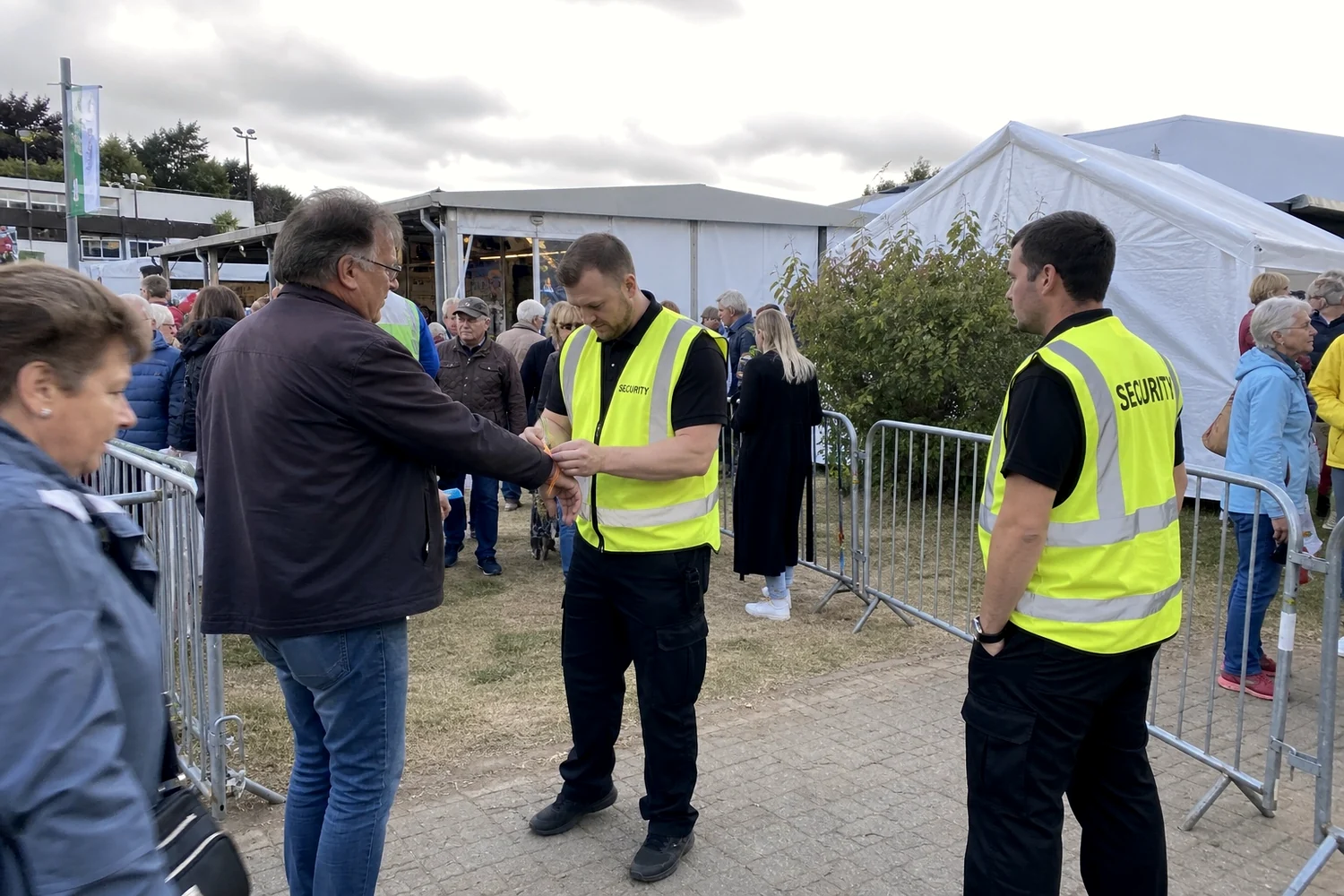 Ordner in Warnwesten an Absperrgittern auf einem Festgelände